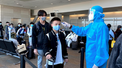 Nhân viên y tế kiểm tra nhiệt độ của hành khách ở sân bay (Ảnh - BYT) 