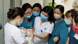 Bé Bình An trong vòng tay của các bác sĩ tại Bệnh viện Đa khoa Xanh Pôn (Ảnh: Lê Minh) 