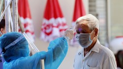 Nhân viên y tế kiểm tra nhiệt độ cho người dân (Ảnh: Bộ Y tế) 