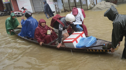 Người dân di chuyển khi nước lũ dâng cao (Ảnh: Hoàng Triều - Nguồn: baothuathienhue.vn)