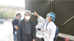 Nhân viên y tế kiểm tra nhiệt độ cho người dân (Ảnh - Minh Thuý) 