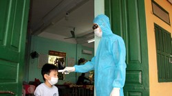 Nhân viên y tế kiểm tra nhiệt độ cho trẻ (Ảnh - HY) 