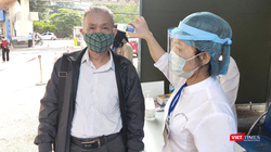 Nhân viên y tế đo nhiệt độ cho người dân (Ảnh - Minh Thuý) 