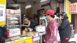 Người dân xếp hàng mua xôi bán mang về (Ảnh - Minh Thuý) 