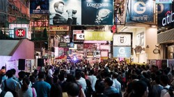 Du khách trên đường phố ở quận Mong Kok của Hồng Kông - Ảnh: Bloomberg