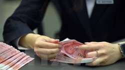 Nhân viên ngân hàng kiểm tiền 100 nhân dân tệ mới tại một ngân hàng ở Bắc Kinh. (Nguồn: THX/TTXVN)