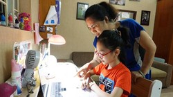 Phụ huynh trợ giúp con khi học trực tuyến - Ảnh: Hanoimoi.com.vn