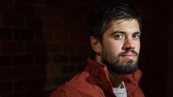 Ảnh chân dung của một người đàn ông với nguồn sáng chính từ đèn flash của điện thoại