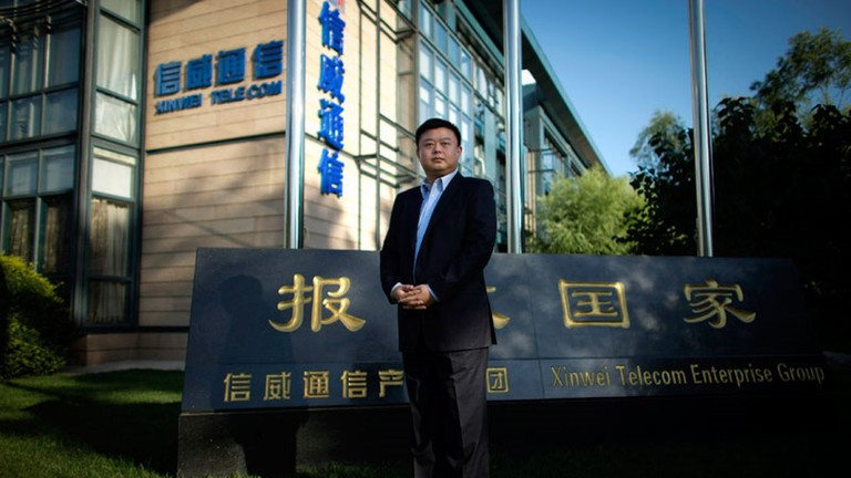 Vương Tịnh đứng trước trụ sở Tập đoàn Xinwei với Slogan "Báo hiếu quốc gia" (Ảnh: Sina)