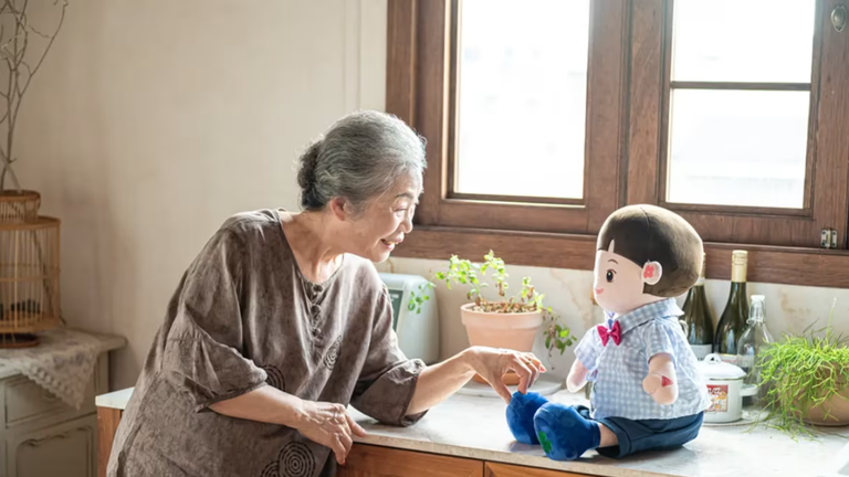 Một phụ nữ lớn tuổi tương tác với chú robot nhồi bông Hyodol được hỗ trợ bởi AI. Ảnh: Hyodol.