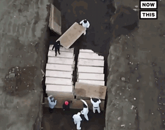 Các tù nhân vận chuyển các quan tài xuống hố (Ảnh: Guancha).