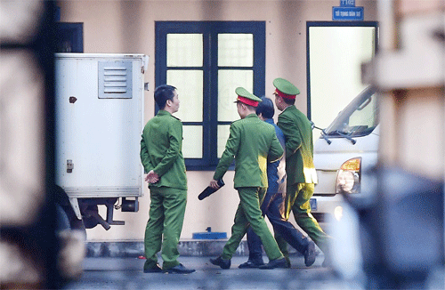 Bị can bị áp giải vào khu vực xét xử. Trong 5 người hầu toàcó hai cựu thứ trưởng Bộ Công an được tại ngoại. Ảnh: Giang Huy