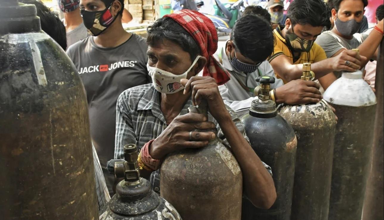 Người dân ở New Delhi xếp hàng chờ tới lượt đổ đầy bình oxy (Ảnh: AP)