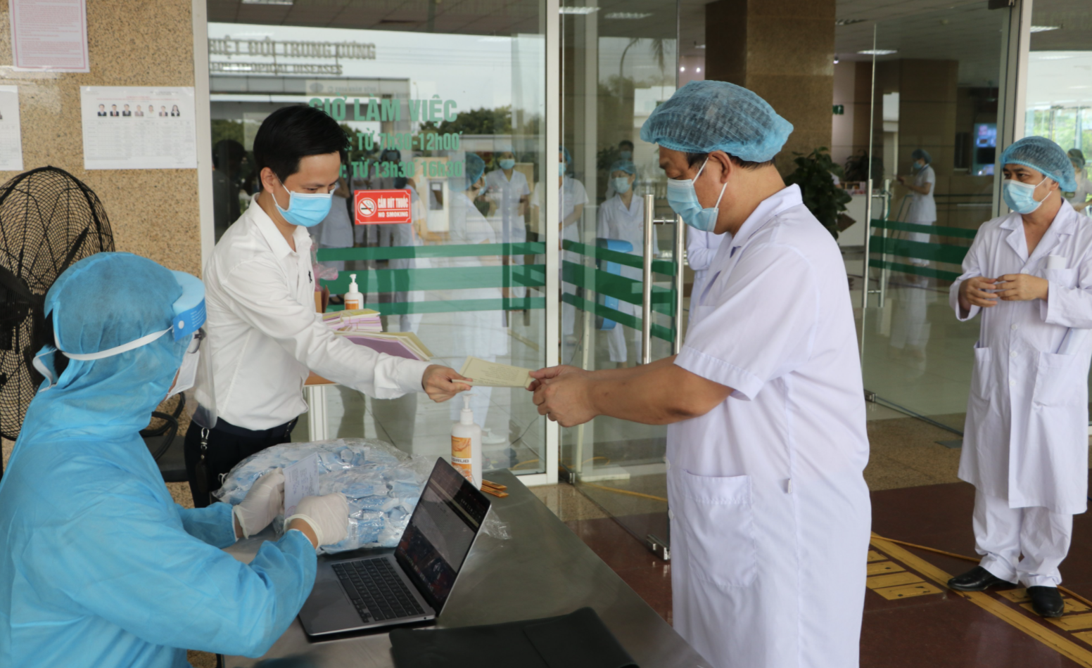 Các bác sĩ, nhân viên y tế rửa tay sát khuẩn, nhận phiếu bầu cử (Ảnh - Đặng Thanh)