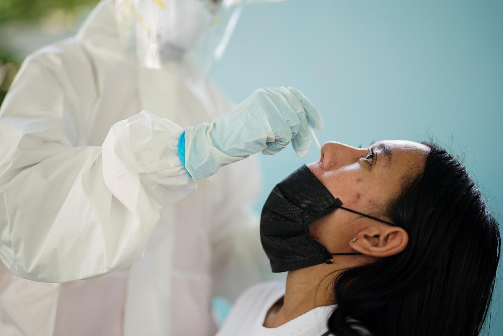 Dùng tăm bông ngoáy mũi lấy dịch để xét nghiệm (Ảnh: Reuters).