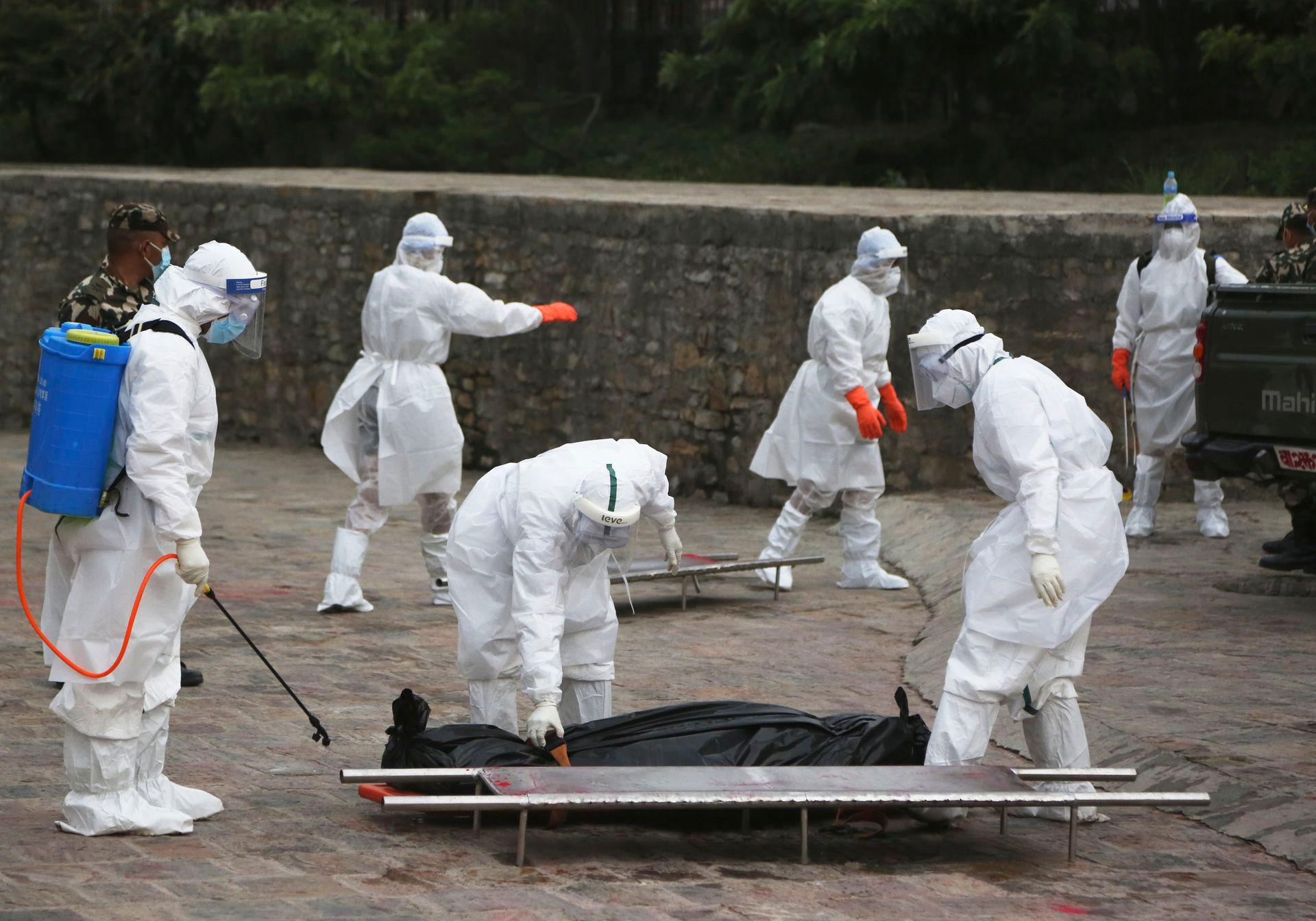 Quân đội đi thu gom các nạn nhân chết vì COVID-19 mang đi thiêu (Ảnh: AP). Quân đội đi thu gom các nạn nhân chết vì COVID-19 mang đi thiêu (Ảnh: AP).