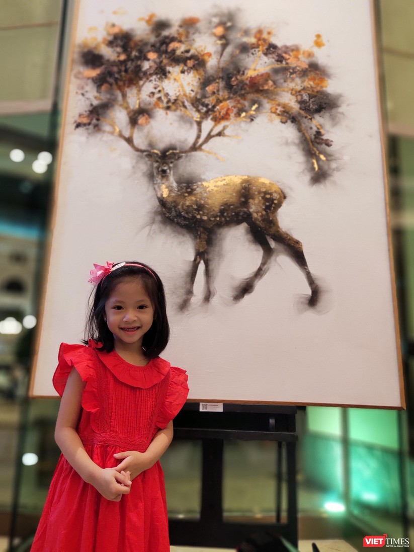 Em bé say sưa chiêm ngưỡng các tác phẩm với chủ đề thiên nhiên của họa sĩ Trung Nghĩa 