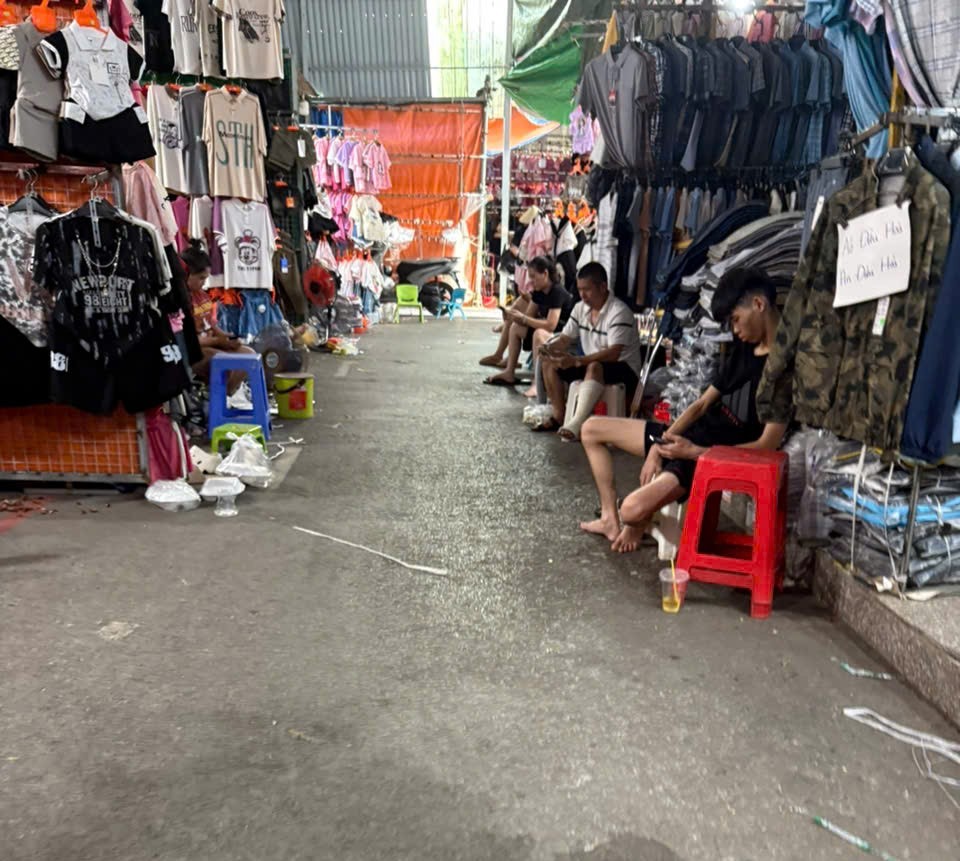 Nhiều tiểu thương rảnh rỗi, vừa trông hàng vừa lướt điện thoại khi không có khách hàng ghé thăm. 6d.jpg