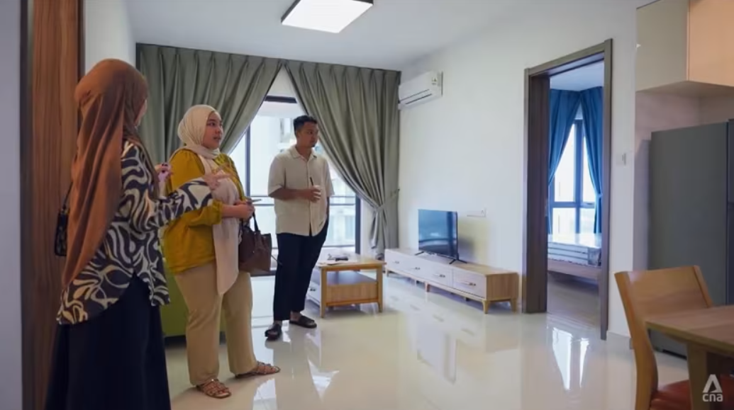 Wafa Aina Wahid (ở giữa) cùng chồng và người môi giới nhà ở tại căn hộ mẫu ở Forest City. Ảnh: CNA. Hồi sinh Forest City Cú cược lớn của Malaysia vào thành phố ma 100 tỷ USD 2.png