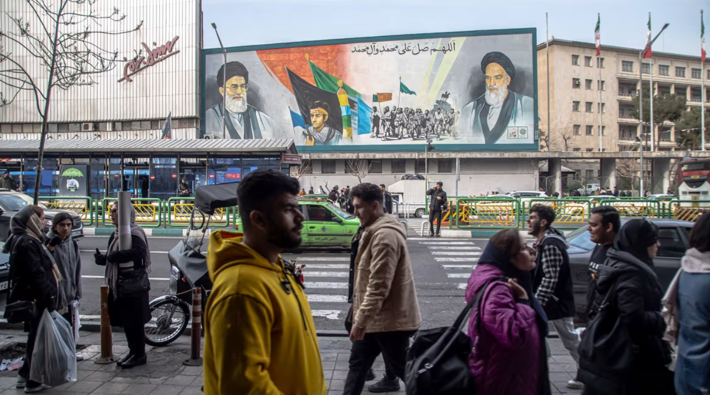 Người dân Iran đi bộ dọc theo các con phố ở Tehran, Iran, vào ngày 24/2/2024. Một bức tranh tường trên Đại lộ Enqelab có hình ảnh nhà Lãnh tụ tối cao Ali Khamenei. Ảnh: AFP. Mỹ–Israel và lời đe dọa thay đổi chế độ Iran Những viễn cảnh nào có thể xảy ra 1.png