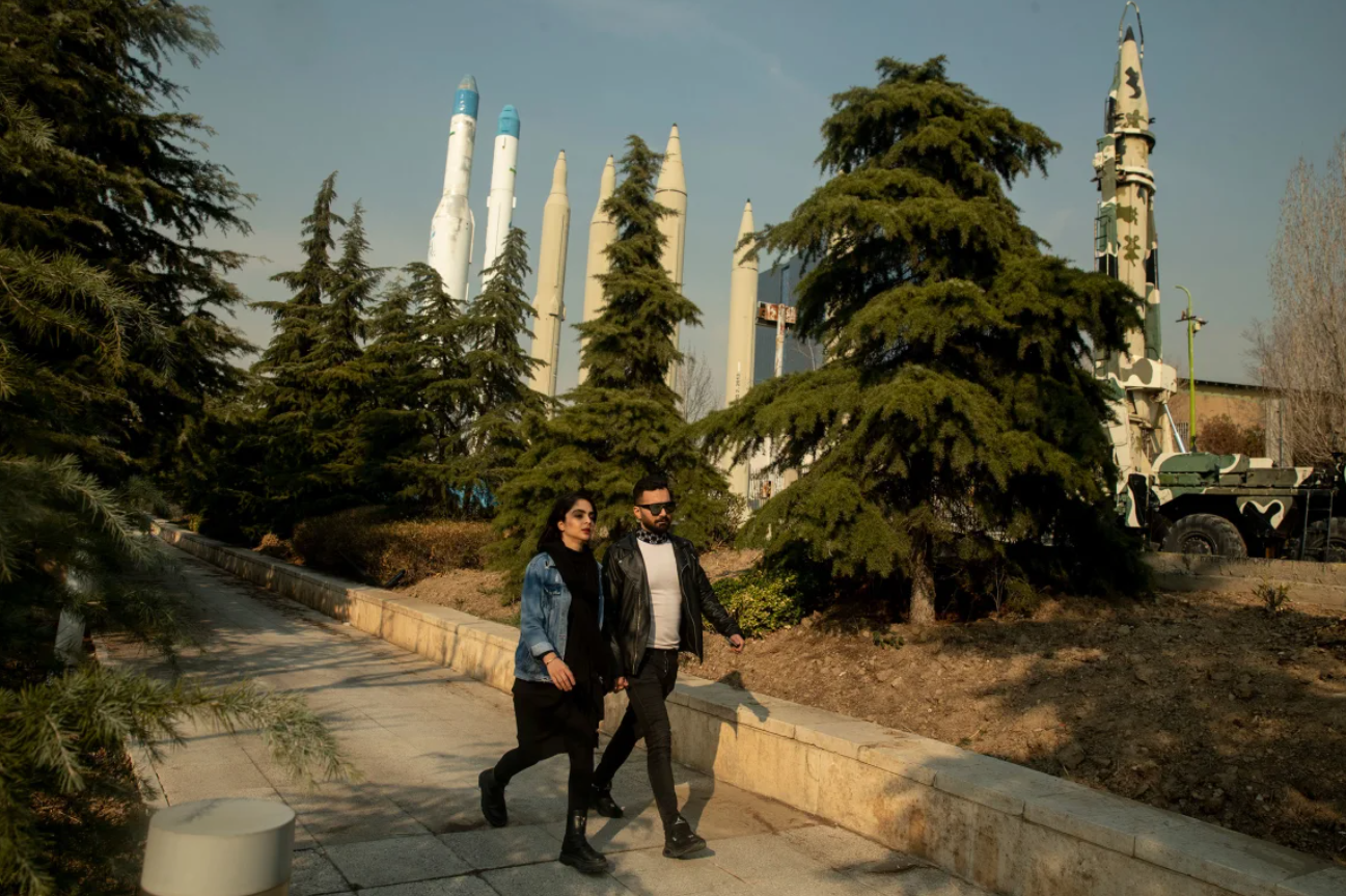 Một cặp đôi người Iran đang đi dạo trong công viên, với những tên lửa được trưng bày ở phía sau tại Tehran, Iran, vào ngày 20/1/2024. Ảnh: Getty. Mỹ–Israel và lời đe dọa thay đổi chế độ Iran Những viễn cảnh nào có thể xảy ra 3.png