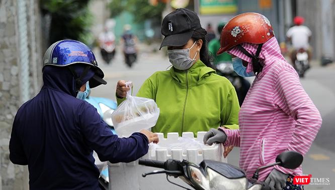 Người dân TP.HCM chia sẻ với nhau những phần cơm từ thiện ngay trên đường phố trong những ngày dịch Covid-19 bùng phát tháng 7/2021