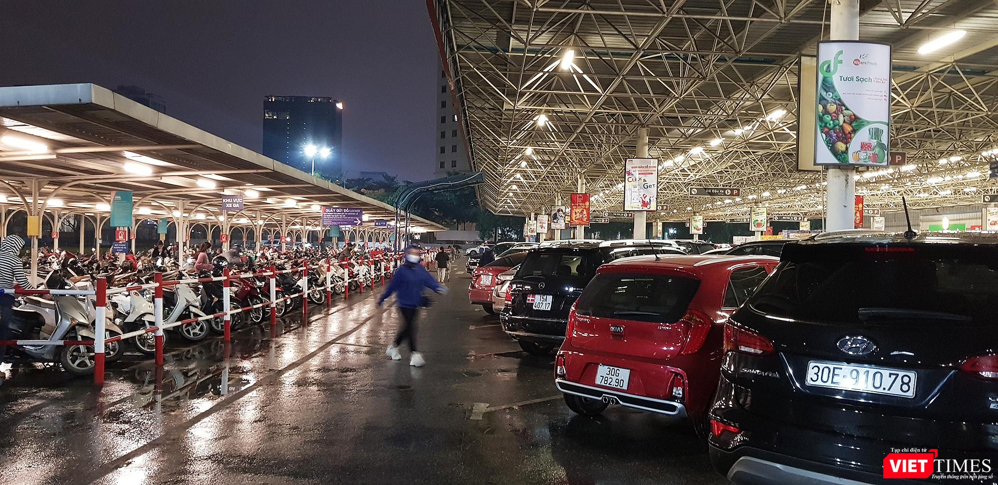 Cả xe máy và xe hơi đỗ kín khoảng sân trước cửa siêu thị. Có thể thấy lượng người đi mua sắm Tết vào chiều tối ngày 28 Tết rất đông đúc