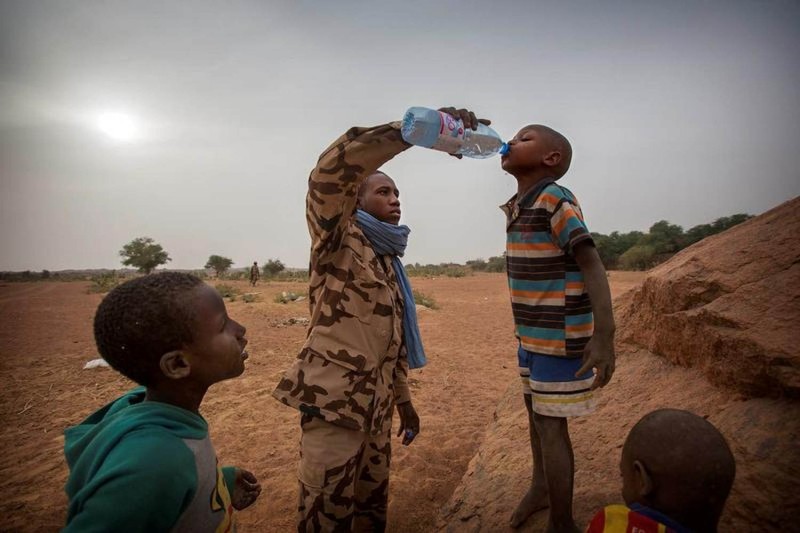 Một thành viên của đội MINUSMA Chadian cung cấp nước cho một cậu bé ở Kidal, Mali ngày 17.12.2016. Ảnh: Reuters