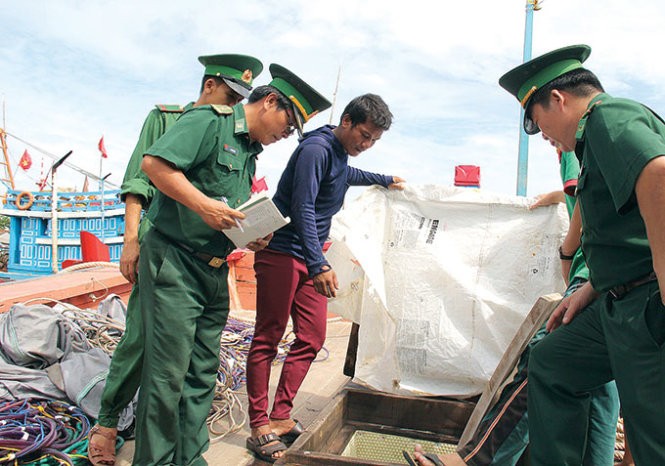 Ngư dân báo cáo với lực lượng biên phòng việc bị tàu Trung Quốc cướp phá - Ảnh: TRẦN MAI