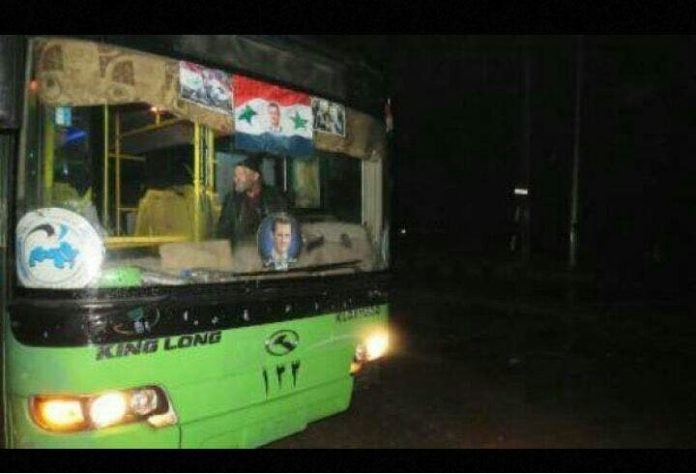 Xe buýt màu xanh của chính quyền Syria chở chiến binh thánh chiến lên đường về Idlib