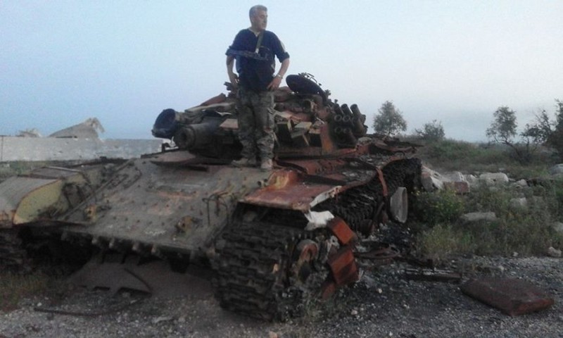 Một chiếc xe tăng phiến quân bị hủy diệt trên chiến trường Hama - Idlib. Ảnh Masdar News
