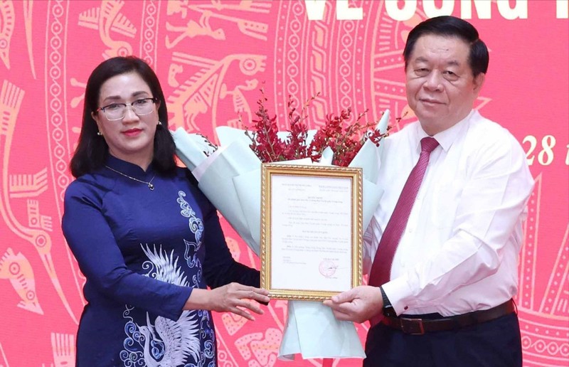 Trưởng Ban Tuyên giáo Trung ương Nguyễn Trọng Nghĩa trao quyết định cho bà Đinh Thị Mai. Ảnh: TTXVN
