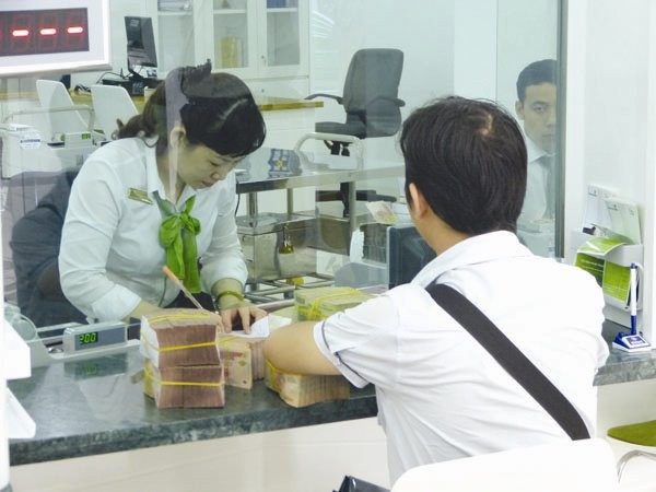 Giao dịch tại Vietcombank. Đây là một trong số ít ngân hàng có mức trả cổ tức bằng tiền ở mức 10-12%/năm. Ảnh: UYÊN VIỄN