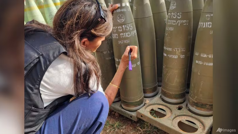 Cựu Đại sứ Mỹ tại Liên Hợp Quốc Nikki Haley ký tên vào đạn pháo của Israel khi đi thị sát biên giới phía bắc của Israel với Lebanon vào ngày 28/5 (Ảnh: AFP)