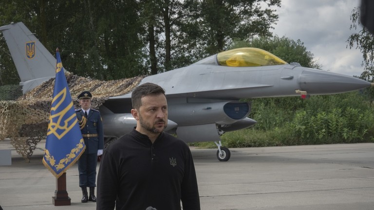 Tổng thống Ukraine Volodymyr Zelensky đứng trước máy bay chiến đấu F-16 do phương Tây tài trợ tại một địa điểm không được tiết lộ ở Ukraine ngày 4/8 (Ảnh: RT)