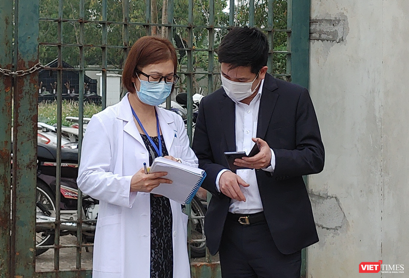 Nhân viên y tế làm việc bên ngoài cổng Trường Tiểu học Xuân Phương vào chiều qua (1/2) (Ảnh - Khánh Linh) 
