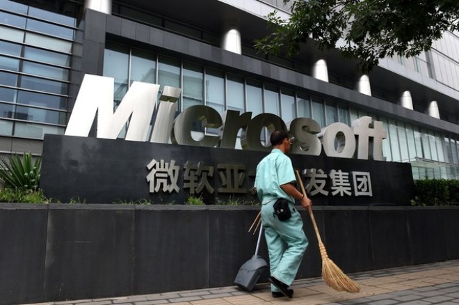 Một công nhân đi ngang qua văn phòng Microsoft tại Bắc Kinh (Ảnh: Bloomberg)