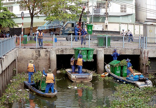 Hiện việc vớt lục bình, rong cỏ chủ yếu bằng xuống. Ảnh: Sơn Hòa