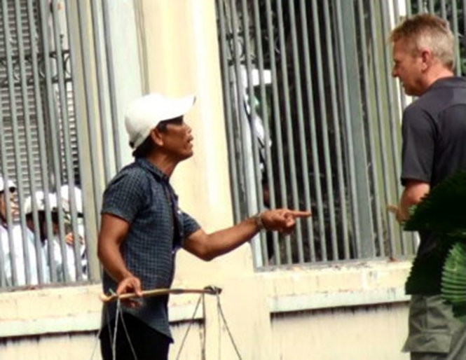 Một người trong nhóm bán dừa trên đường Nam Kỳ Khởi Nghĩa(TP.HCM) đang chèo kéo, yêu cầu du khách nước ngoài phải trả 5 USD (tương đương trên 100.000 đồng)/trái dừa - Ảnh: Đức Phú