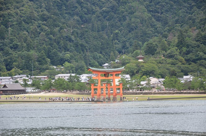 Cổng nổi Torii nhìn từ bến phà Miyajima, nổi lên giữa mặt biển xanh ngọc cùng núi non hung vĩ bao quanh