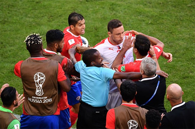 Tiền vệ người Serbia, Nemanja Matic, bị các cầu thủ Costa Rica cản lại sau một cuộc đụng độ với một trong những huấn luyện viên của họ.