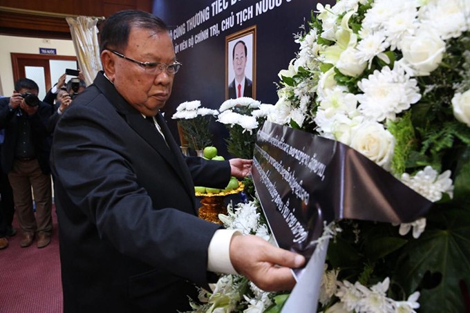 Sáng 26/9, Đại sứ quán Việt Nam tại Lào tổ chức Lễ viếng Chủ tịch nước Trần Đại Quang, đồng thời mở sổ tang để lãnh đạo, các cơ quan, đoàn thể, các đoàn ngoại giao, tổ chức quốc tế tại Lào đến viếng và ghi sổ tang. Sau nghi lễ treo cờ rủ trước trụ sở Đại sứ quán là lễ dâng hương tưởng niệm. Tổng Bí thư - Chủ tịch nước Lào Bounnhang Vorachith đã đến đặt vòng hoa, thắp hương viếng Chủ tịch nước Trần Đại Quang. Ảnh: Hà Trung