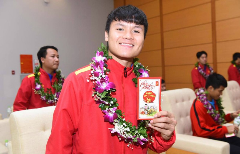 Các thành viên đội tuyển nhận tiền lì xì trong buổi tiếp đón tại sân bay (Ảnh: VnExpress) Quang Hải nhận tiền lì xì