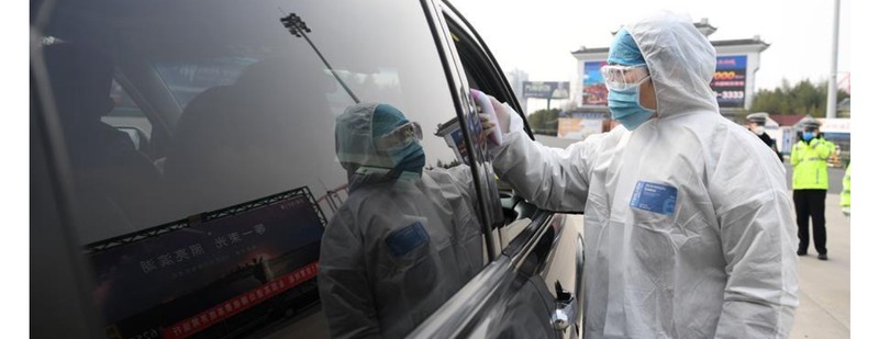 Nhân viên y tế đo thân nhiệt người đi đường ở Hồ Bắc (Ảnh: Guancha)