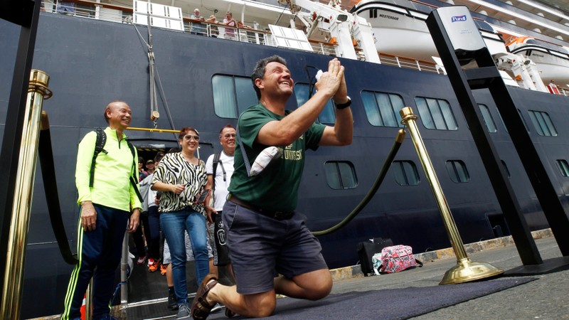 Một hành khách không kìm nén được sự sung sướng khi được lên bờ sau nhiều ngày lênh đênh trên biển (Ảnh: AP) Một hành khách không kìm nén được sự sung sướng khi được lên bờ sau nhiều ngày lênh đênh trên biển (Ảnh: AP)