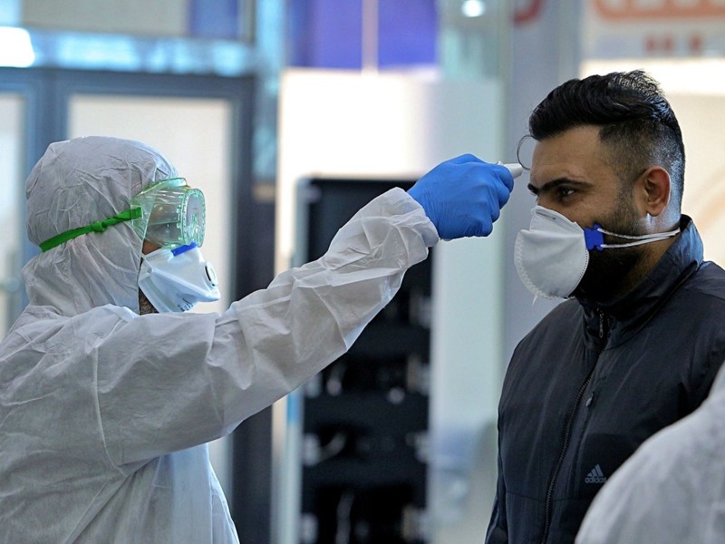 Nhân viên kiểm dịch đo thân nhiệt hành khách bay từ Iran tới ở sân bay Najaf (Ảnh: AP). Nhân viên kiểm dịch đo thân nhiệt hành khách bay từ Iran tới ở sân bay Najaf (Ảnh: AP).