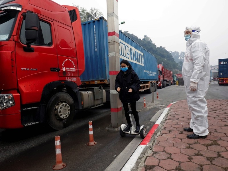 Các tài xế xe tải qua lại biên giới được trang bị phương tiện phòng hộ (Ảnh: Reuters).