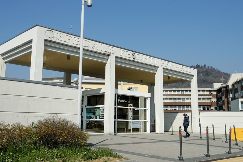 Một người phụ nữ đi bộ bên ngoài Bệnh viện Pesenti Fenaroli ở Bergamo (Ảnh: AP)