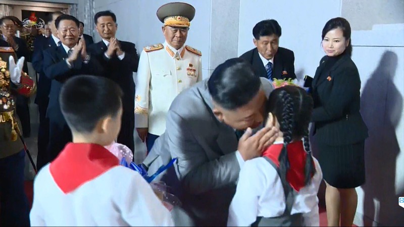 Tại cuộc diễu binh hôm 10/10, bà Hyon Song-wol nhận hoa của các thiếu nhi tặng ông Kim Jong-un (Ảnh: Reuters).