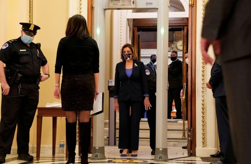 Công tác an ninh trong Điện Capitol được siết chặt. Trong ảnh: Chủ tịch Hạ nghị viện Nancy Pelosi chuẩn bị bước qua máy soi kim kim loại (Ảnh: Reuters) Công tác an ninh trong Điện Capitol được siết chặt. Trong ảnh: Chủ tịch Hạ nghị viện Nancy Pelosi chuẩn bị bước qua máy soi kim kim loại (Ảnh: Reuters)
